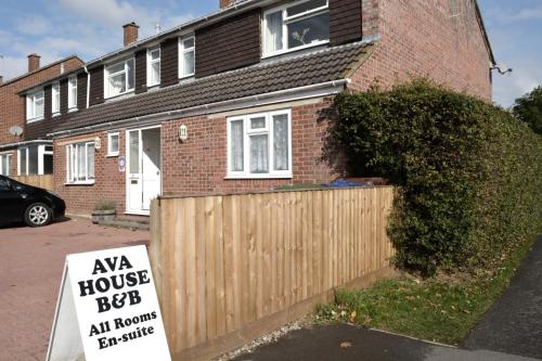a house with a sign in front of a fence at Ava House Bed and Breakfast in Bicester