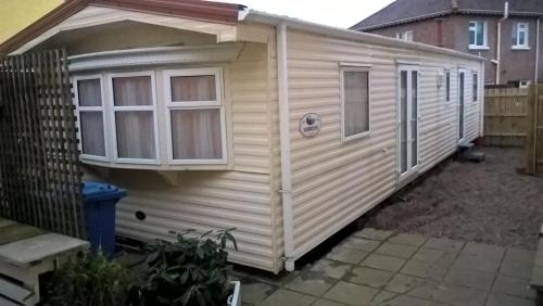 an exterior view of a wooden caravan with windows at Aaranmore Lodge Guest House in Portrush