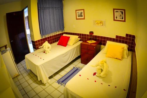a bedroom with two beds with stuffed animals on them at Pousada das Bromélias in Porto De Galinhas