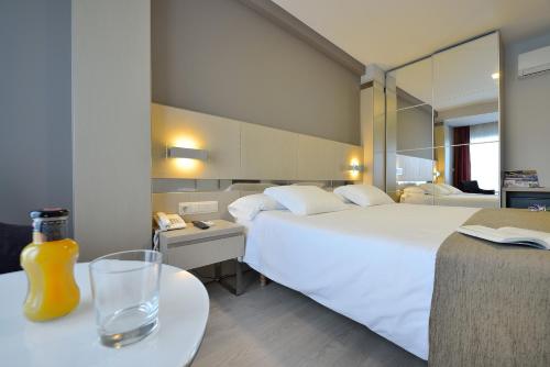 A bed or beds in a room at Hotel Puente de La Toja