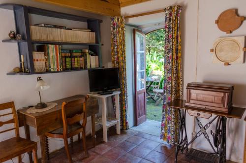 a room with a desk and a tv and a table at Quinta do Espírito Santo in Angra do Heroísmo