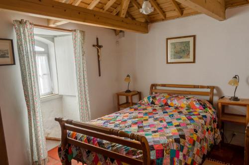 a bedroom with a bed and a cross on the wall at Quinta do Espírito Santo in Angra do Heroísmo