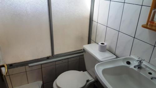 a bathroom with a toilet and a sink at Hostal Vista al Mar hct in Ancud