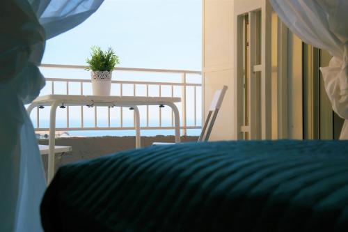 アーチ・トレッツァにあるVilla Albaのベッド1台と植物のあるテーブルが備わる部屋
