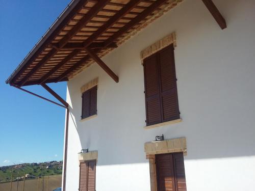 a white house with two windows and a roof at B&B Itufi in Colonnella