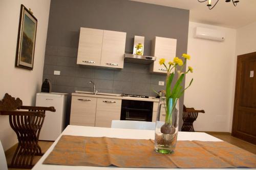 a kitchen with a table with a vase of flowers on it at Suite Umberto I in Assisi