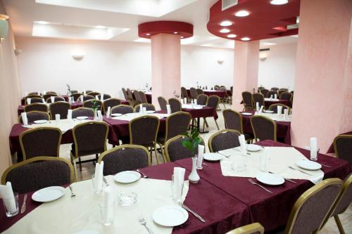 a room filled with tables and chairs with purple table cloth at Victoria Hotel in Jerusalem