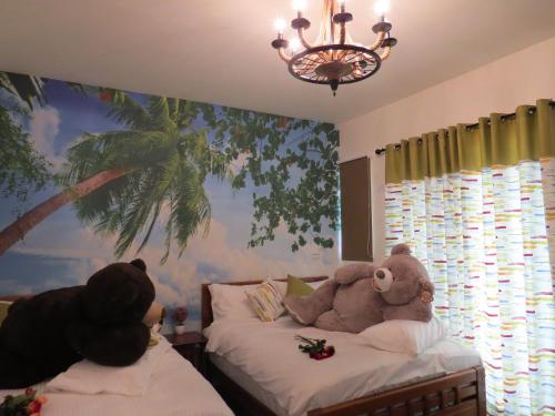 a bedroom with two beds with teddy bears on them at Hai Yang Homestay in Jian