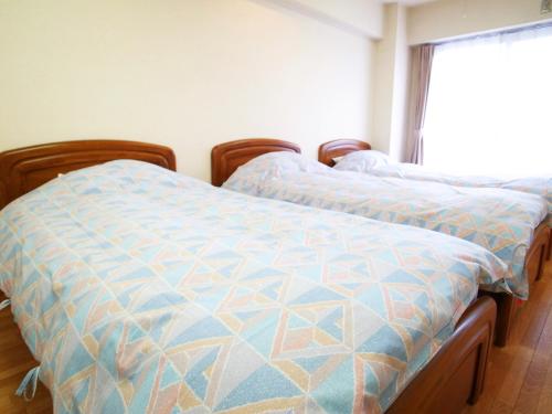 2 camas individuales en una habitación con ventana en FLEXSTAY INN Tamagawa en Kawasaki