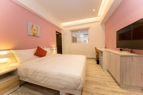 a bedroom with a bed and a flat screen tv at 177 Guest House in Nantou City