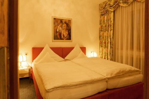 ein Schlafzimmer mit einem großen weißen Bett in einem Zimmer in der Unterkunft Hotel Angelika in Sankt Anton am Arlberg