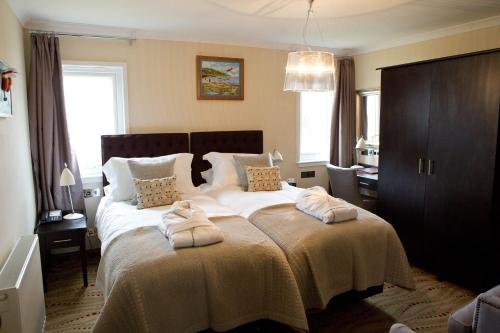 um quarto com uma cama grande com duas toalhas em The Waterfront Boutique Hotel em Stanley