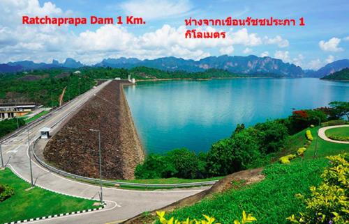 a view of a lake with a road next to it at Belong Jin The Dam Hotel And Resort in Ban Pha Saeng Lang