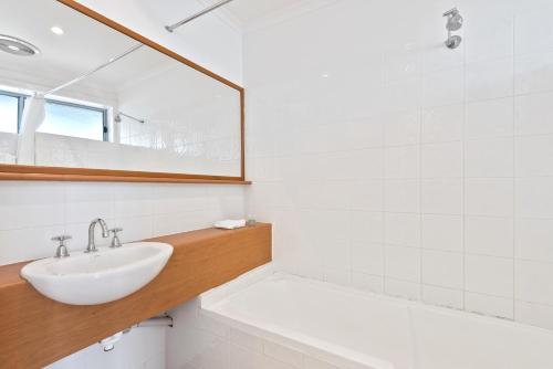 a white bathroom with a sink and a mirror at North Pier Hotel in Cowes