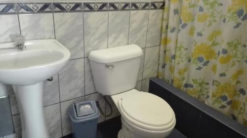 a bathroom with a white toilet and a sink at Hostal Killaymi in Arequipa