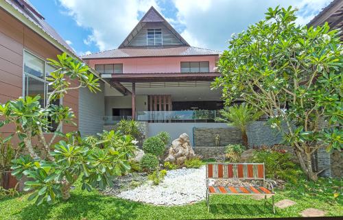 a house with a bench in the front yard at Krabi Home Town Boutique in Krabi town