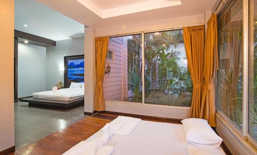 a bedroom with a bed and a large window at Krabi Home Town Boutique in Krabi town