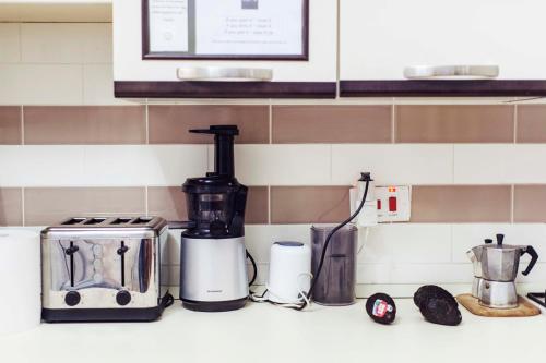 a kitchen counter with a coffee maker and a toaster at Granny's Inn Hostel in Sliema
