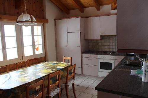 een keuken met een grote tafel en stoelen. bij Chalet Spinne in Grindelwald