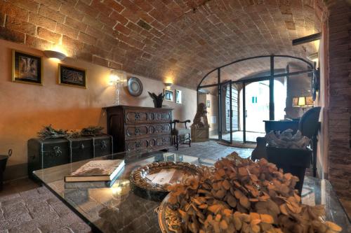 a living room with a glass table and a brick wall at Antica Dimora Leones in Palaia
