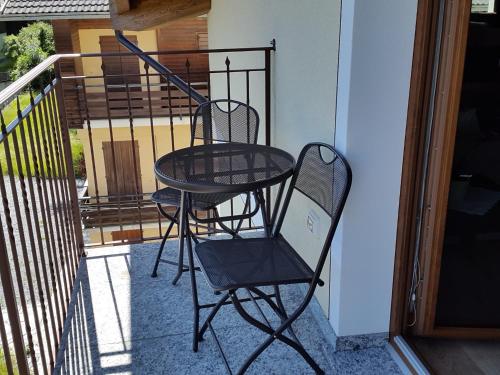 a black chair sitting on a balcony next to a door at Casa Reit in Bormio