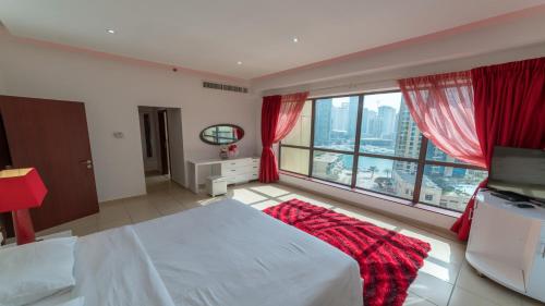 a bedroom with a white bed and a large window at Jbr Beach Walk Rimal 3 in Dubai
