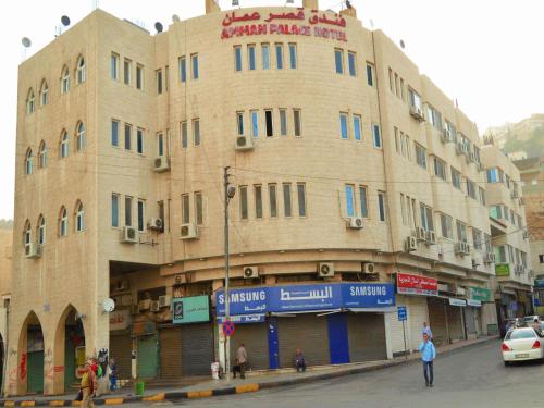 a large building on the corner of a street at Amman Palace Hotel in Amman