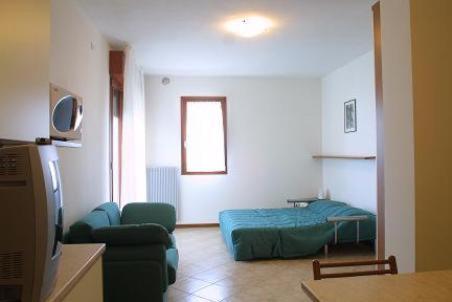 a living room with a couch and a bed at Residence Mini Sayonara in Lido di Jesolo
