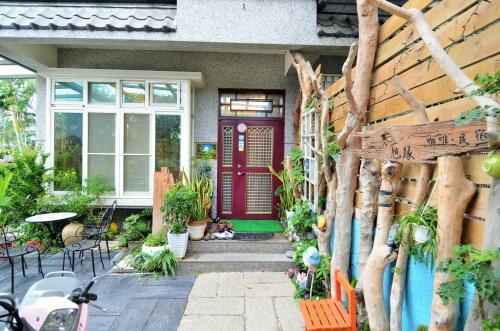 a red front door of a house with plants at 旭緣咖啡民宿 in Taitung City