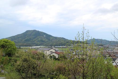 a mountain in the distance with houses and trees at South Wind Chalet in Itoshima