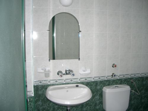 bagno con lavandino, specchio e servizi igienici di Hotel Levteri a Primorsko