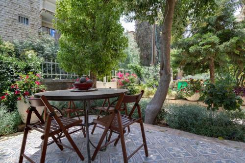 a table with chairs and a bowl of fruit on it at Brand New Gem In Talbiyeh in Jerusalem