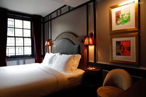 a hotel room with a bed and a window at Mimi's Hotel Soho in London