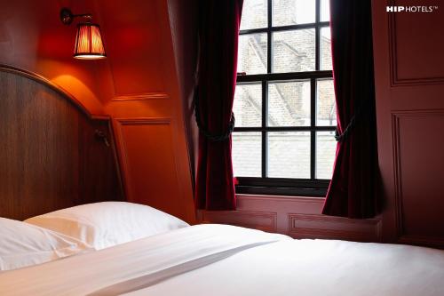 a bedroom with a bed and a window at Mimi's Hotel Soho in London