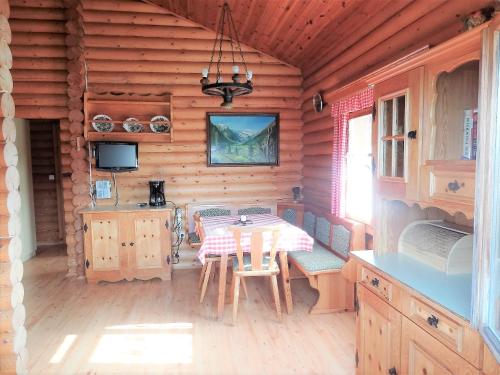 - une salle à manger avec une table et des chaises dans une cabine dans l'établissement Blockhaus-Bärnkopf, à Bärnkopf