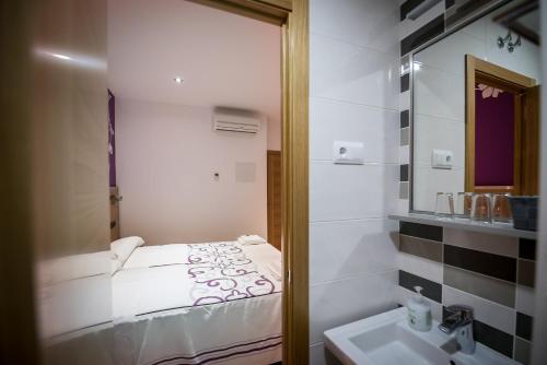 マドリードにあるホスタル カラセドのバスルーム(鏡に映るベッド付)