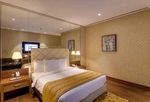 um quarto de hotel com uma cama grande e uma secretária em Niranta Transit Hotel Terminal 2 Arrivals/Landside em Mumbai