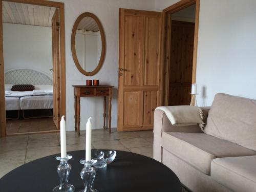 a living room with a couch and a table with candles at Knasborg Ferieboliger in Ålbæk