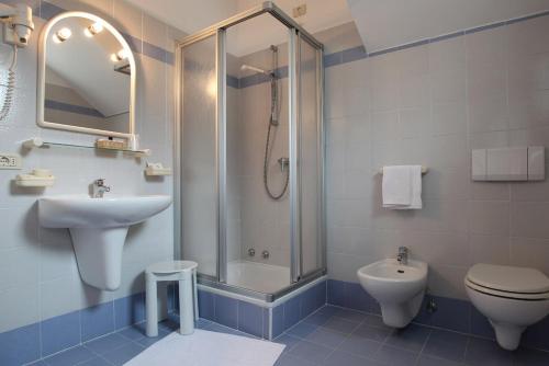 a bathroom with a sink and a toilet and a shower at Hotel Garnì Villanova in Molveno