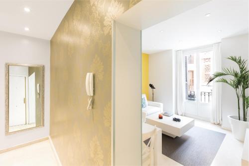 un salon avec un mur jaune dans l'établissement Carretas Apartments, à Madrid