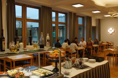 a dining room with people sitting at tables in a restaurant at Kloster Neustadt in Neustadt an der Weinstraße