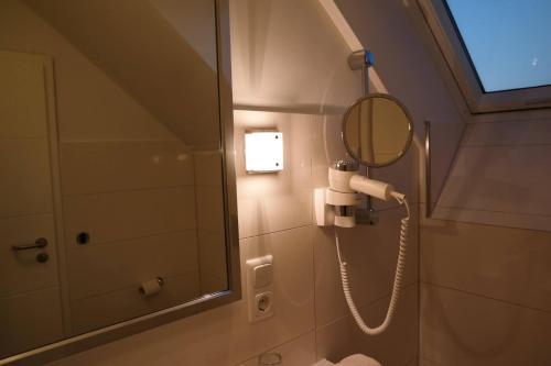 a bathroom with a blow dryer and a mirror at Hotel Restaurant Zum Hollengrund in Heeslingen