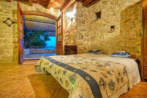 sypialnia z łóżkiem i kamienną ścianą w obiekcie Holiday Getaway Caric w mieście Ivan Dolac