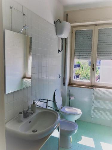 a white bathroom with a sink and a toilet at Attico vista mare in Pescara