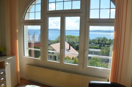a room with three windows with a view of the water at Appartements Vacances Saars 33 in Neuchâtel