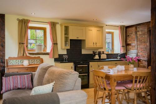 cocina y sala de estar con sofá y mesa en The Bothy Self Catering Accommodation en Rousky