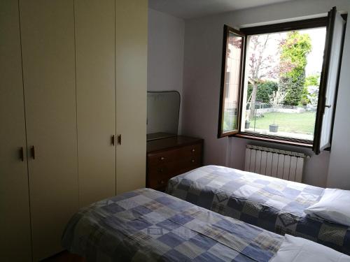 a bedroom with two beds and a window at Pellico Apartment in Brusaporto