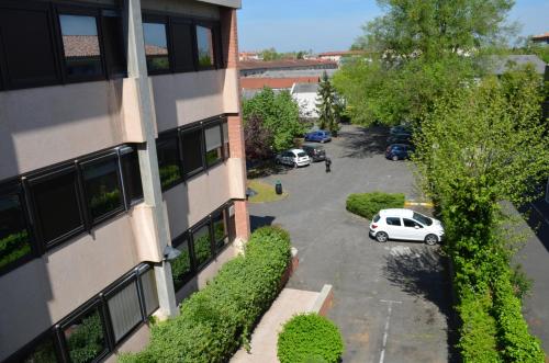 - une vue aérienne sur un parking situé à côté d'un bâtiment dans l'établissement Kyriad Direct Montauban Centre, à Montauban