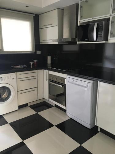 a kitchen with white appliances and a black and white checkered floor at Apart Edificio Clever in La Plata