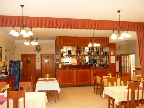 a restaurant with tables and chairs and a bar at Ádám Tanya Fogadó in Balázspuszta